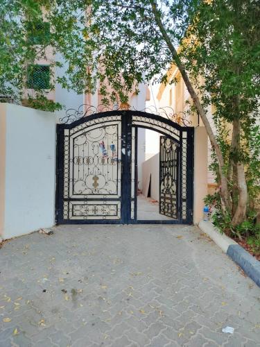 a black gate in front of a building at Private Guest Room in Kuwaitat in Al Ain