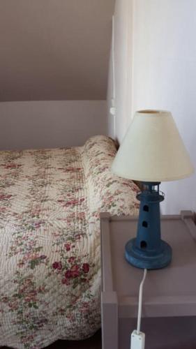 une lampe bleue sur une table à côté d'un lit dans l'établissement Charmante maison à 3 minutes à pied d'une plage magnifique, à Erquy