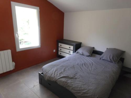 - une chambre avec un lit, une commode et une fenêtre dans l'établissement Gîte du Pic Saint loup, à Valflaunès