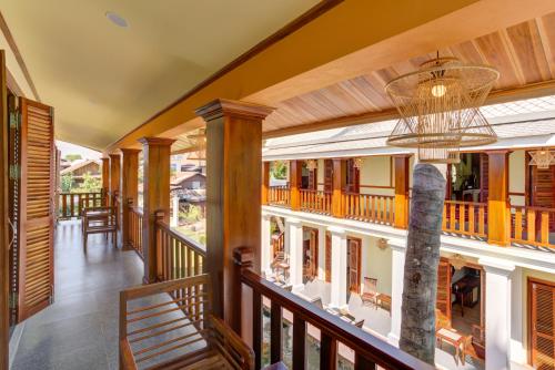 an indoor balcony of a house with a chandelier at Elegant Boutique Hotel Luangprabang in Luang Prabang
