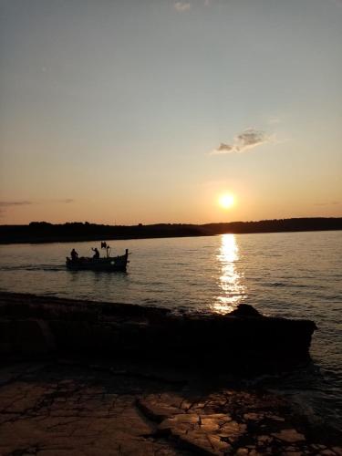 a group of people in a boat on the water at sunset at Hvaretta Villas in Stari Grad