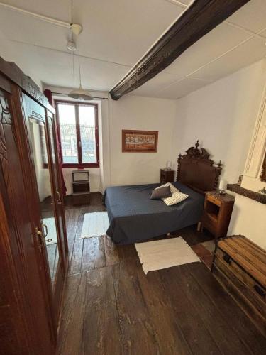 une chambre avec un lit et un parquet dans l'établissement Chez Nath et Oli, à Caunes-Minervois