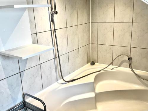 a bath tub in a bathroom with tiled walls at Apartment to Düsseldorf - near Airport DUS - Trade Fair - Arena in Düsseldorf