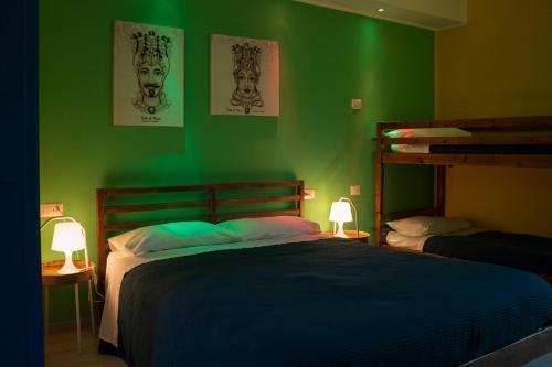 a bedroom with green walls and two bunk beds at Sicilia Bedda Taormina in Taormina