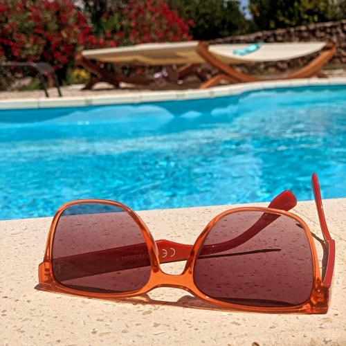 a pair of sunglasses sitting next to a swimming pool at Hvaretta Villas in Stari Grad