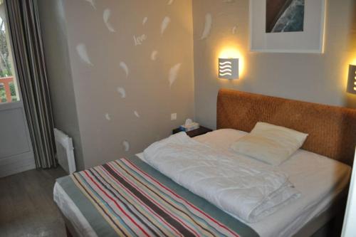 - une chambre dotée d'un lit avec des draps blancs dans l'établissement Les jardins de la cote d opale 2 chambres, à Le Touquet-Paris-Plage