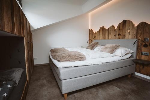a bedroom with a bed with a wooden wall at Panorama Lodge Edelweiss in Gosau