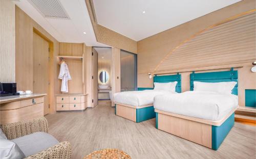 a hotel room with two beds and a tv at WM Hotel Hong Kong, Vignette Collection in Hong Kong