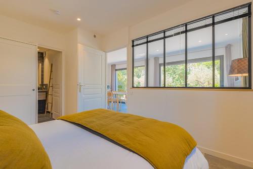une chambre avec un lit et une grande fenêtre dans l'établissement L'atelier, à Saint-Tropez