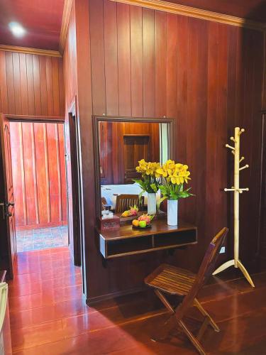 a room with a table with flowers and a chair at Luang Prabang Mekong Charm River View in Luang Prabang