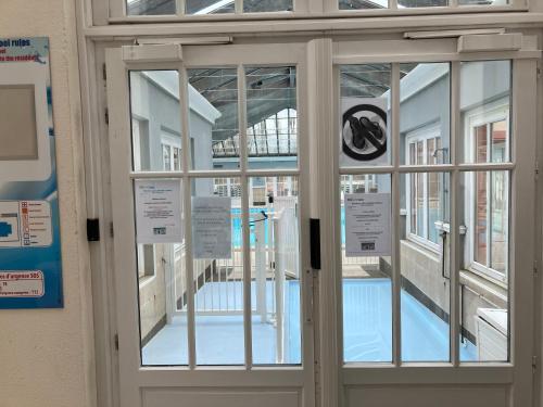 - une porte menant à une piscine dans un bâtiment dans l'établissement Les jardins de la cote d opale 2 chambres, à Le Touquet-Paris-Plage