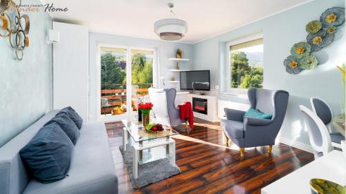 カルパチにあるWonder Home - Apartamenty w cichej i zielonej części Karpacza - z miejscem na grilla i parkingiemのソファと椅子とテレビのあるリビングルーム