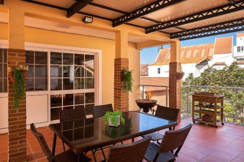 an outdoor patio with a table and chairs at villa com piscina entre o mar e as montanhas in Paul do Mar