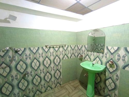a bathroom with a green sink and a mirror at Sisara Sun Hill in Mirissa