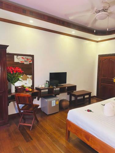 a bedroom with a desk with a computer and a bed at Luang Prabang Mekong Charm River View in Luang Prabang