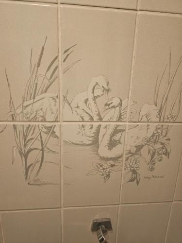 a bathroom tile with two swans in the water at HCR de Zwaan in Kapelle