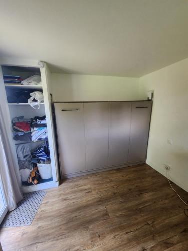 une pièce vide avec un placard et une porte dans l'établissement Studio sur les fleuristes, à Cambo-les-Bains