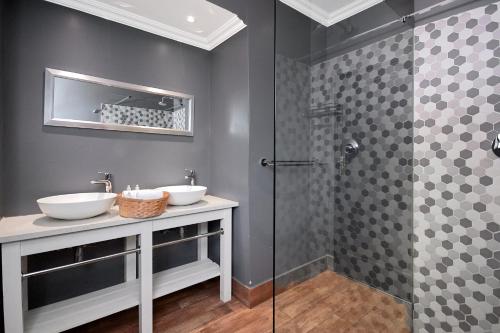 a bathroom with two sinks and a shower at The Stirling in Johannesburg