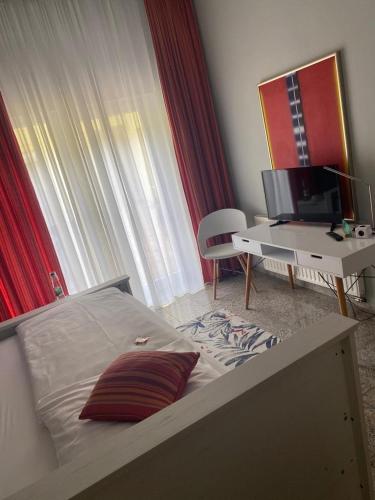 a bedroom with a bed and a desk and a television at Boutique-garni Hotel Papillon in Kempen