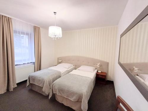 a hotel room with two beds and a window at Hotel i Restauracja Borowianka in Ostrów Wielkopolski