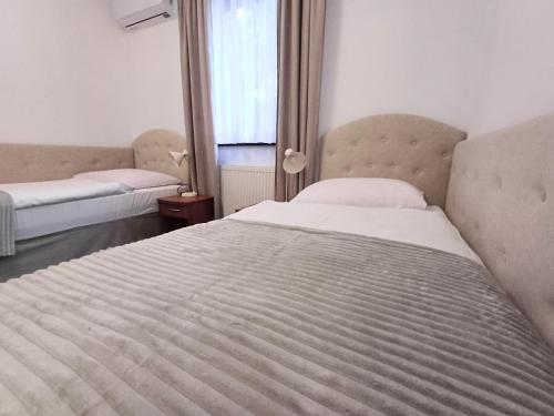 a bedroom with two beds and a window at Hotel i Restauracja Borowianka in Ostrów Wielkopolski
