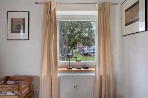 a window with a desk and a lamp on a window sill at Taubenkobel in Groß Wokern