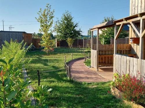 un jardin avec une clôture en bois et un chemin dans l'établissement CHALET VINTAGE - Climatisé - Les Belles Ouvrières, à Clermont-Créans
