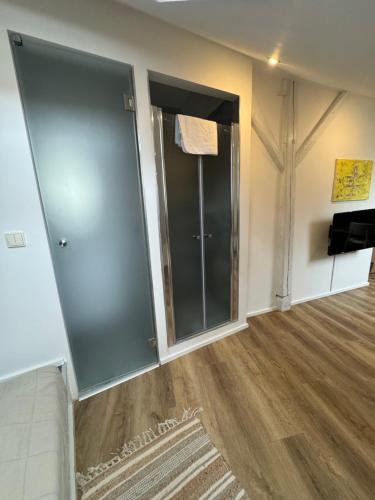 a room with two glass doors and a wooden floor at ADC Design Apartmány in Brno