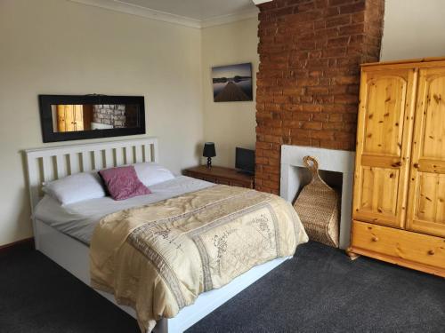 a bedroom with a bed and a brick wall at Charming Cottage Retreat in Chorley in Chorley