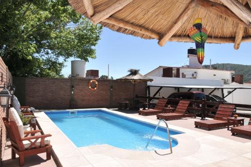 a swimming pool with chairs and a parrot on a roof at Hotel Mirador de las Sierras in Villa Carlos Paz