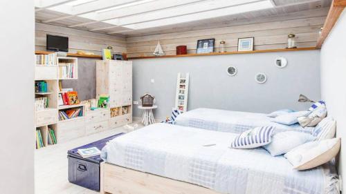 a bedroom with a large bed and bookshelves at Villa luxeuse et climatisee sur le golf, piscine chauffee in Essaouira
