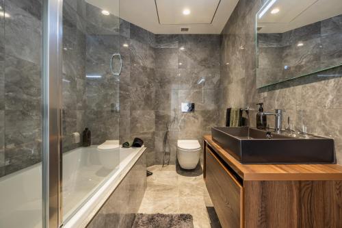 a bathroom with a sink and a tub and a toilet at Apartment on Cloud Nine in Malta's Tallest Tower in St Julian's