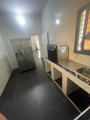 a kitchen with a counter with a refrigerator and a sink at Villa espradis in Toubab Dialaw