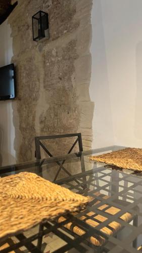 a room with two tables and a stone wall at Apartamentos Jerez Siglo XIX in Jerez de la Frontera