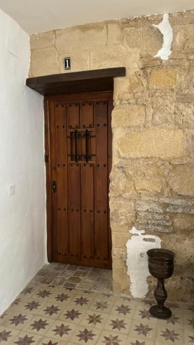 a wooden door in a building with a stone wall at Apartamentos Jerez Siglo XIX in Jerez de la Frontera