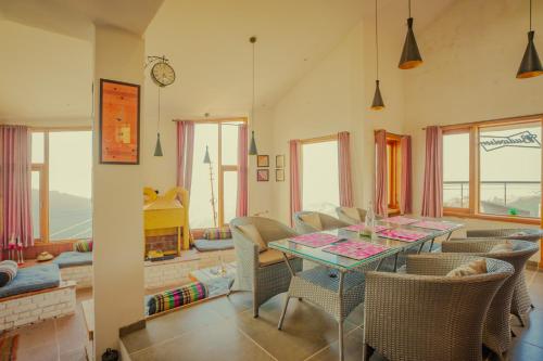 a dining room with a table and chairs at Revaant Retreat in Rāmgarh