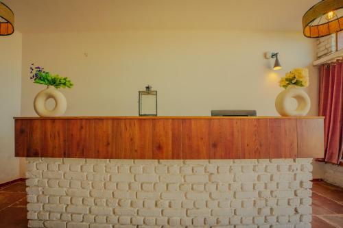 a altar with two vases on top of a brick wall at Revaant Retreat in Rāmgarh