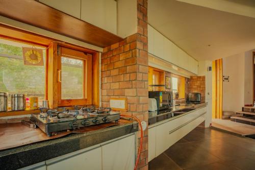 a kitchen with a counter with a stove top oven at Revaant Retreat in Rāmgarh