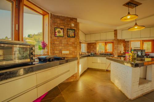 a kitchen with a counter and a brick wall at Revaant Retreat in Rāmgarh
