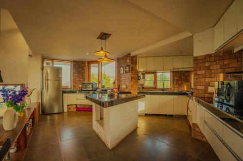 a large kitchen with a counter and a refrigerator at Revaant Retreat in Rāmgarh