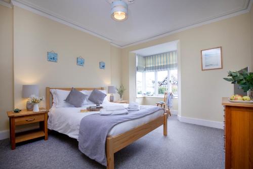 Un dormitorio con una cama grande y una ventana. en Cambridge House, en Sidmouth