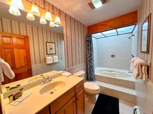 a bathroom with a sink and a tub and a toilet at Bretton Woods home steps from the slopes, AC, pool passes, discounted cog tix! in Bretton Woods