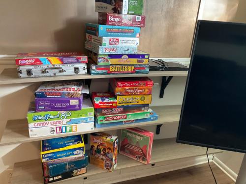 a stack of games on a shelf next to a tv at Gahanna Ranch-Tastic 3-bedroom recently renovated Aug 2024 in Gahanna