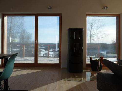 a living room with a large window and a refrigerator at WaldNur in Neureichenau