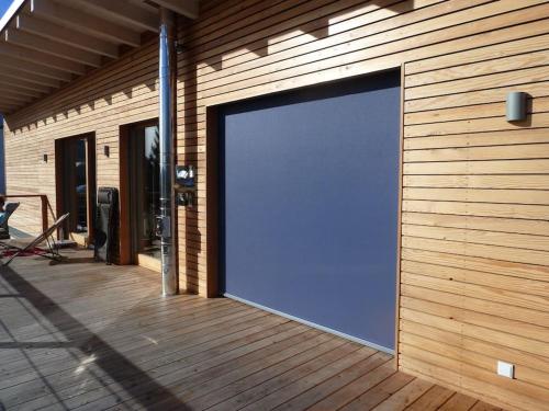 a large blue garage door on a wooden building at WaldNur in Neureichenau