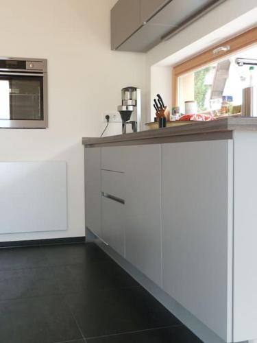 a kitchen with white cabinets and a counter top at WaldNur in Neureichenau