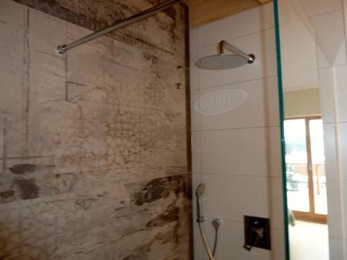 a bathroom with a shower with a stone wall at WaldNur in Neureichenau