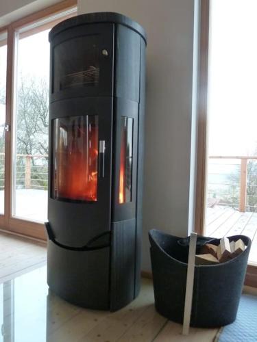 a black fireplace sitting next to a room with a bowl at WaldNur in Neureichenau