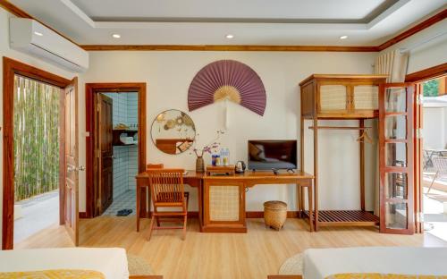 a living room with a desk and a computer at Elegant Boutique Hotel Luangprabang in Luang Prabang