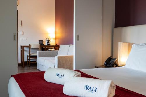 a hotel room with two beds and a red blanket at Hotel Rali Viana in Viana do Castelo